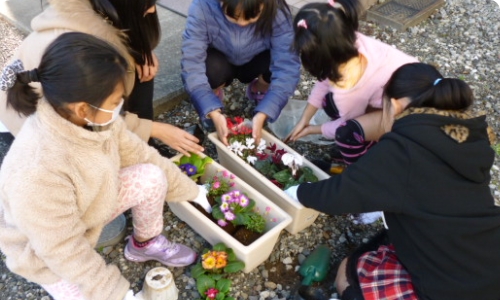 花壇の周りに集まる子供